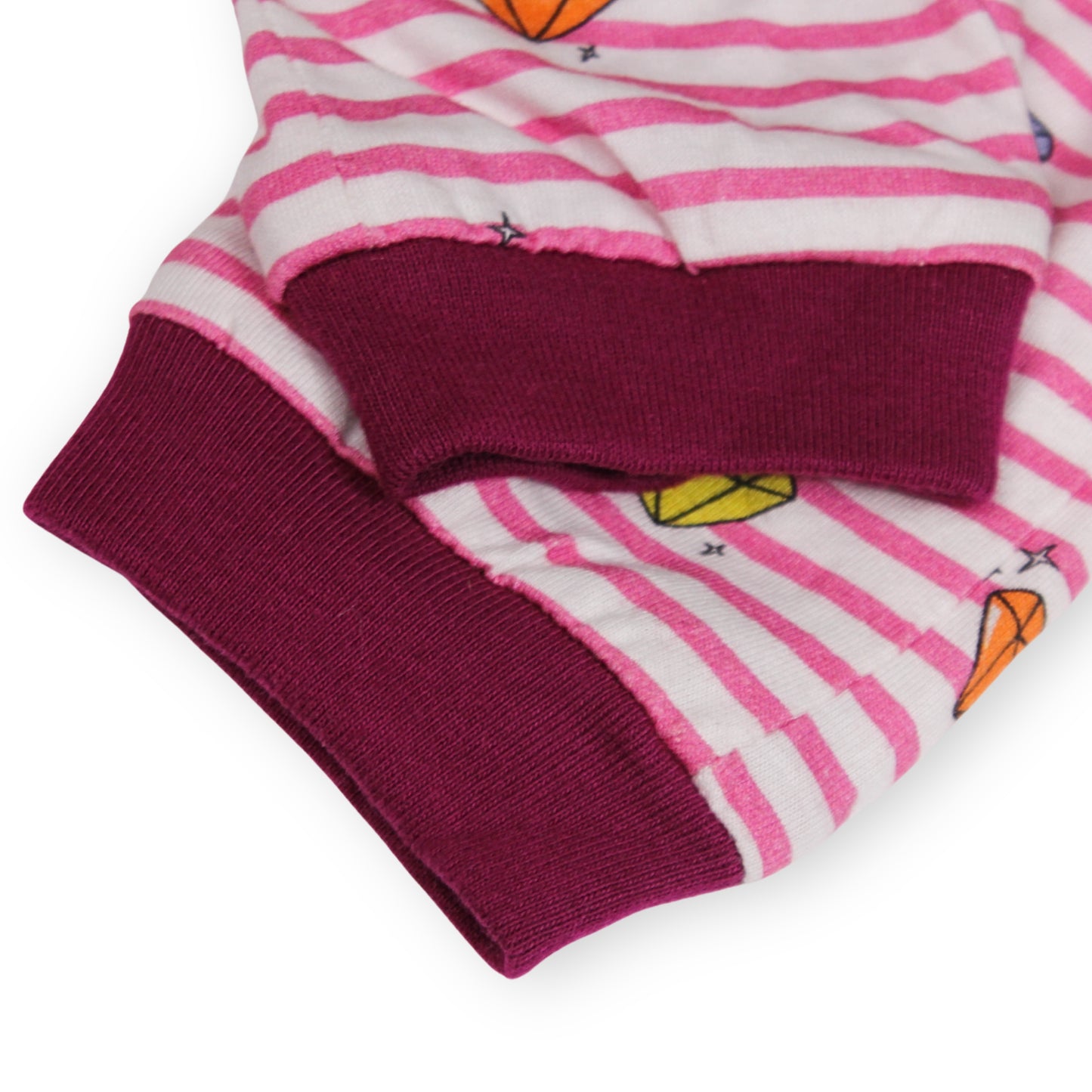 Close-up of a Babydrip Pants cuff. Featuring magenta colored ribbed cuffs and pink and white stripes, and small multicolor diamond graphic prints, laid out on a white background.