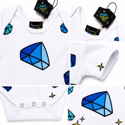 A Babydrip white baby bodysuit onesie collage showing five close up panel views of the garment and its details. The bodysuit onesie features in panel one the front and neck image of the onesie, with large blue and light blue faceted gem graphic on the chest and shoulders. The second panel shows a close up image of the neck area with the clothes tags attached. The third panel shows a close up image of the onesie sleeve. The 4th panel displays the diamonds prints and the fifth shows three snap closure buttons