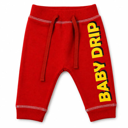 Babydrip Red baby jogger pants with large yellow 'BABY DRIP' text graphic on the right leg, featuring a drawstring waist with white outer stitching on the waist and cuffs. The cuff and waist are also ribbed stretch for comfy and snug fit.