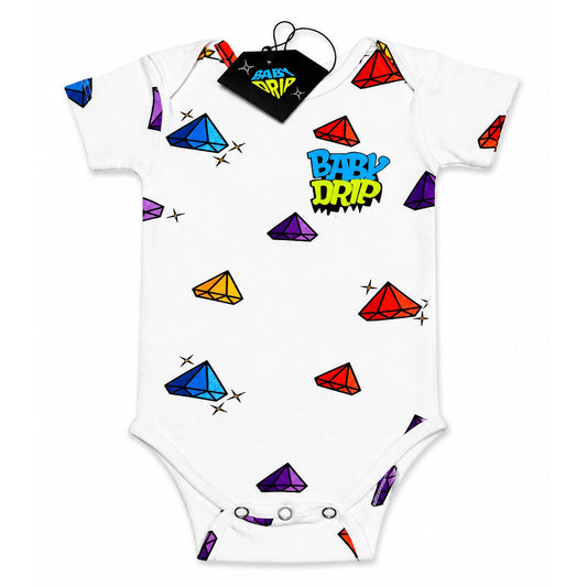 The front image of a Babydrip white short-sleeve baby bodysuit onesie with colorful printed gemstone motifs and a 'BABY DRIP' graphic print on the chest, with three safety snap buttons at the middle of the bottom section. Shown flat on a white background with a black hangtag at the back of the neck.