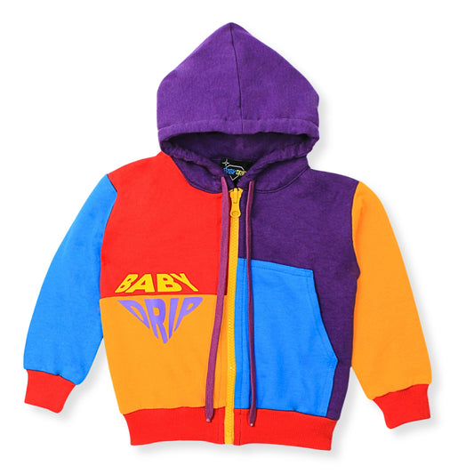 A Babydrip colorful zip-up hoodie for boys with a colorblock design in purple, red, blue, and orange. The front features a yellow graphic text reading 'BABY DRIP' and a yellow zipper with purple drawstrings with red ribbed cuffs and hem.