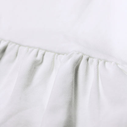 Close-up image of a white fabric product showing a gathered ruffle seam and soft texture from babydrip collection.