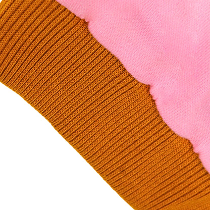 Close-up of a pink terry cotton knit fabric showing a ribbed brown cuff or trim layered over a soft pink plush or fleece section on a white background.
