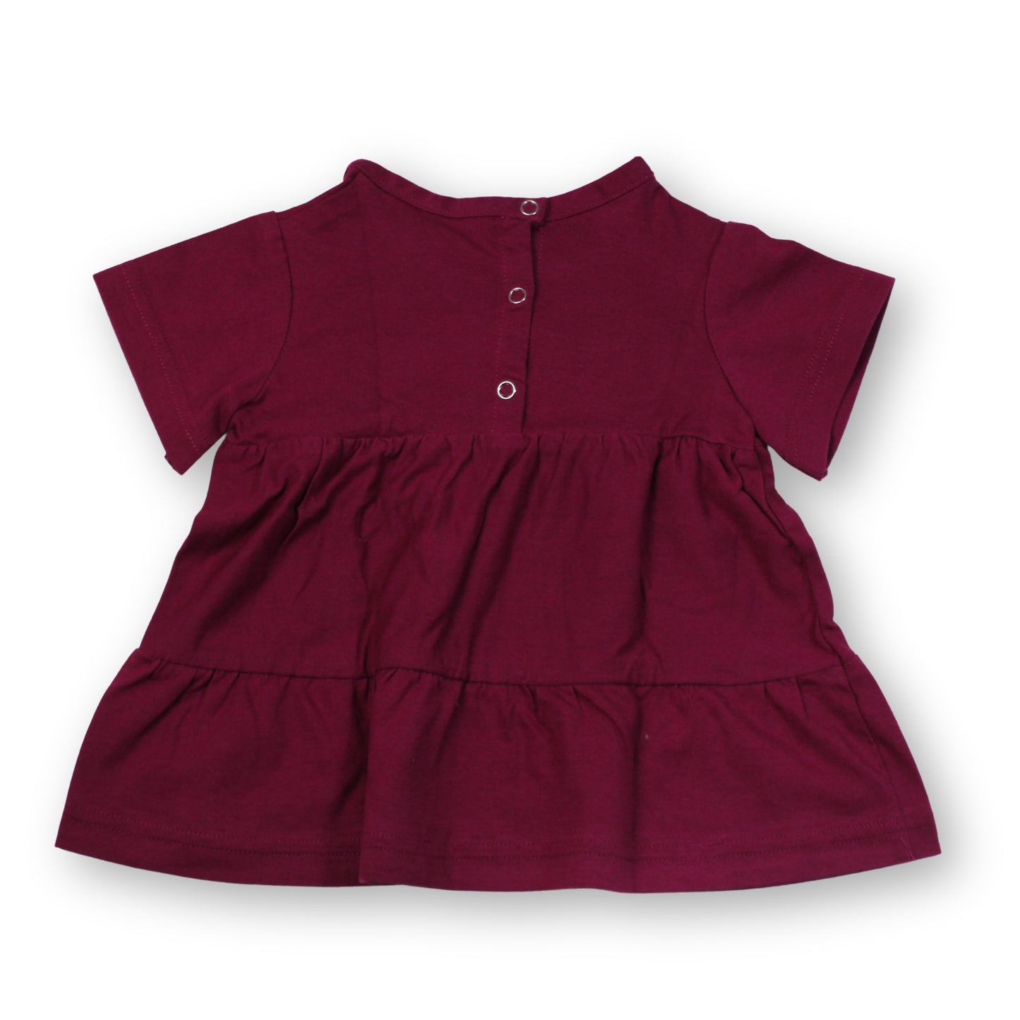 A Babydrip short-sleeve Magenta tunic blouse with a tiered ruffle hem and three snap open and shut silver buttons on the back neckline, shown laid flat against a plain white background.